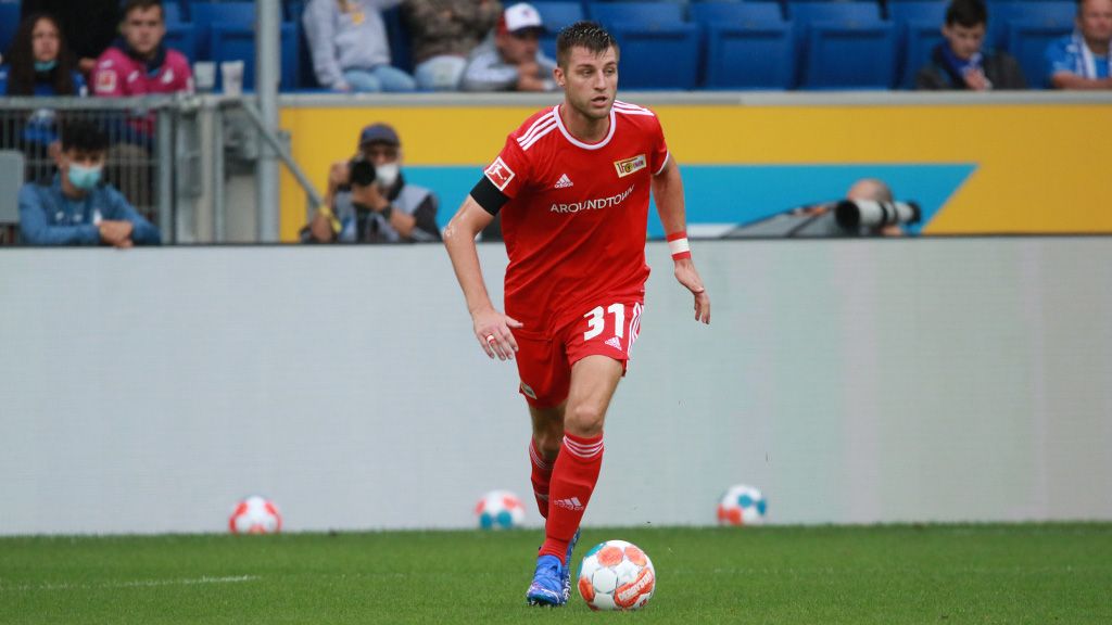 Ein Fußballspieler in rotem Trikot mit der Nummer 31 dribbelt den Ball auf einem Stadionfeld.