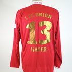 Rotes Fußballtrikot mit goldenen Zahlen "13" und dem Text "Pajer" auf dem Rücken.