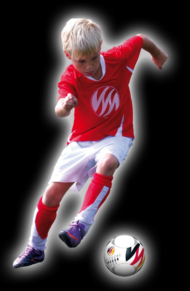 Ein junger Fußballspieler in rotem Trikot läuft und dribbelt einen Fußball.