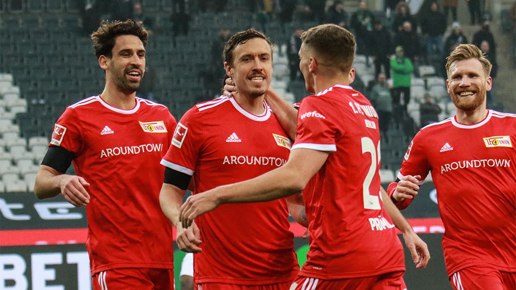 Spieler von Union Berlin feiern ein Tor. Alle tragen rote Trikots mit Sponsorenlogos.