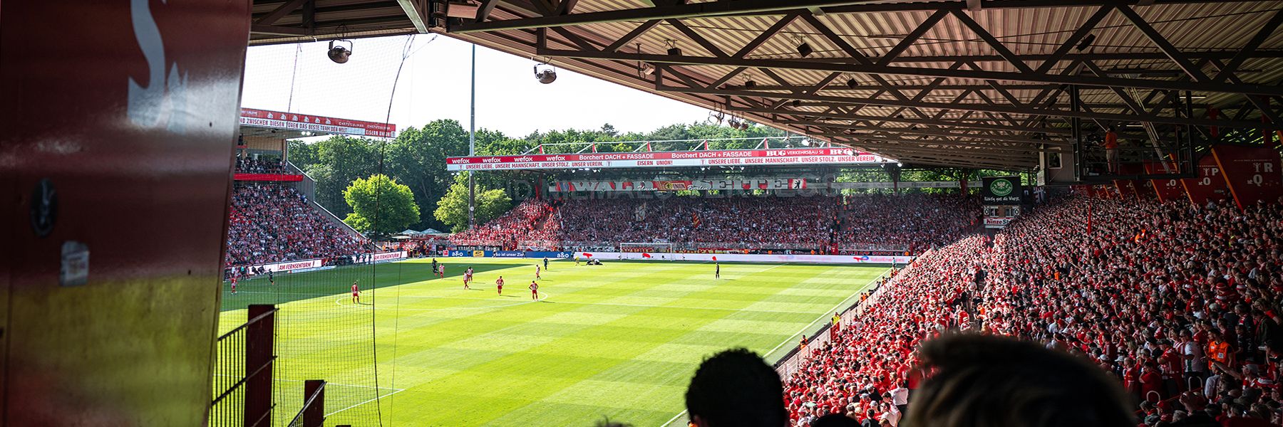 View of a full football stadium with players on the field and spectators enthusiastically watching the game.