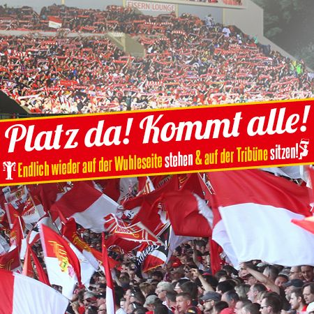 Fans mit roten und weißen Schals in einem Stadion, viele Schilder und Banner, darunter „Platz da! Kommt alle!“
