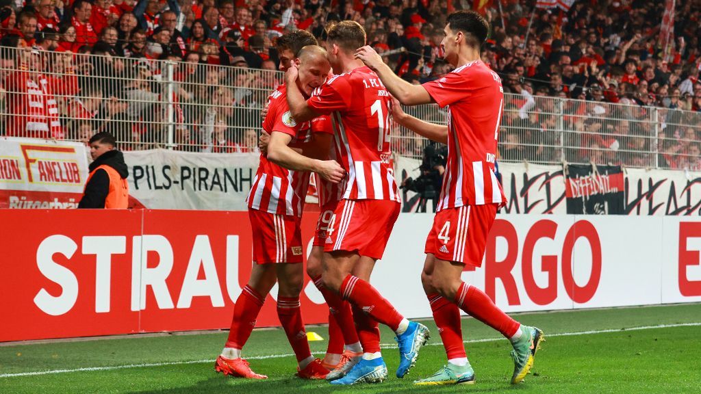 Spieler des 1. FC Union Berlin feiern ein Tor, umgeben von jubelnden Fans im Stadion.