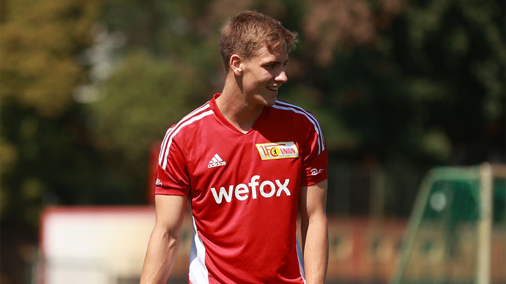 Ein junger Fußballspieler in einem rot-weißen Trikot mit der Aufschrift "wefox" lächelt während des Trainings.