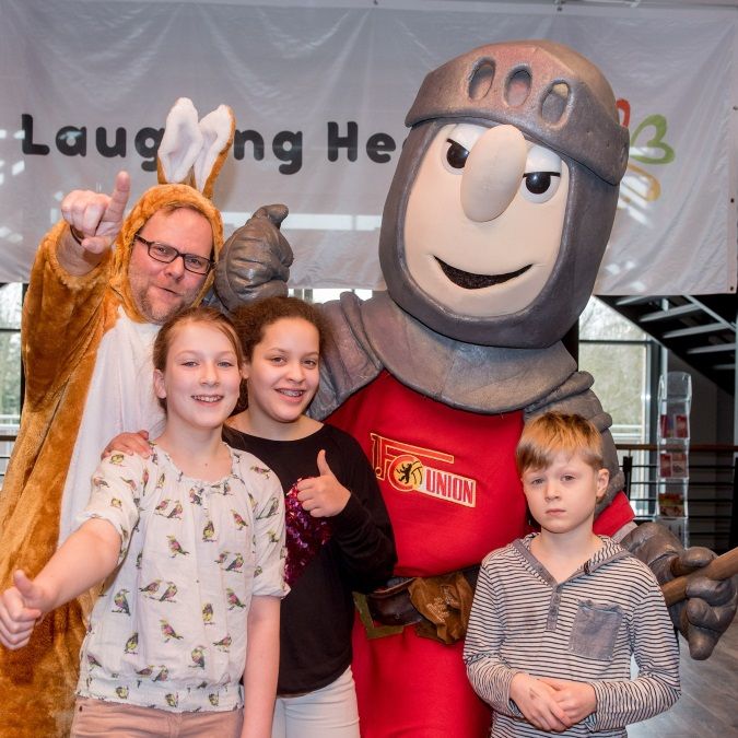 Eine Gruppe von vier Personen posiert für ein Foto: zwei Kinder, ein Junge, ein Mädchen, ein Mann im Kostüm und ein Ritter.