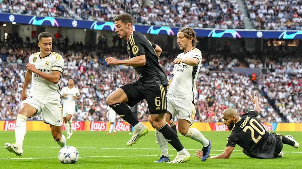 Game scene with players in black and white jerseys on a soccer field during a club competition.