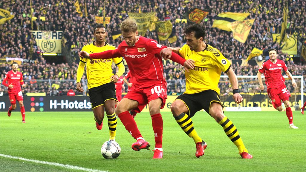 Spielszene im Fußballspiel zwischen Borussia Dortmund und Union Berlin mit Spielern im intensiven Zweikampf.