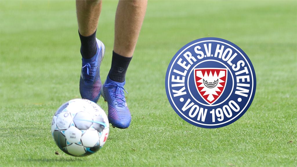 A player in blue soccer shoes kicks a ball on green grass, next to the logo of Kieler SV Holstein.
