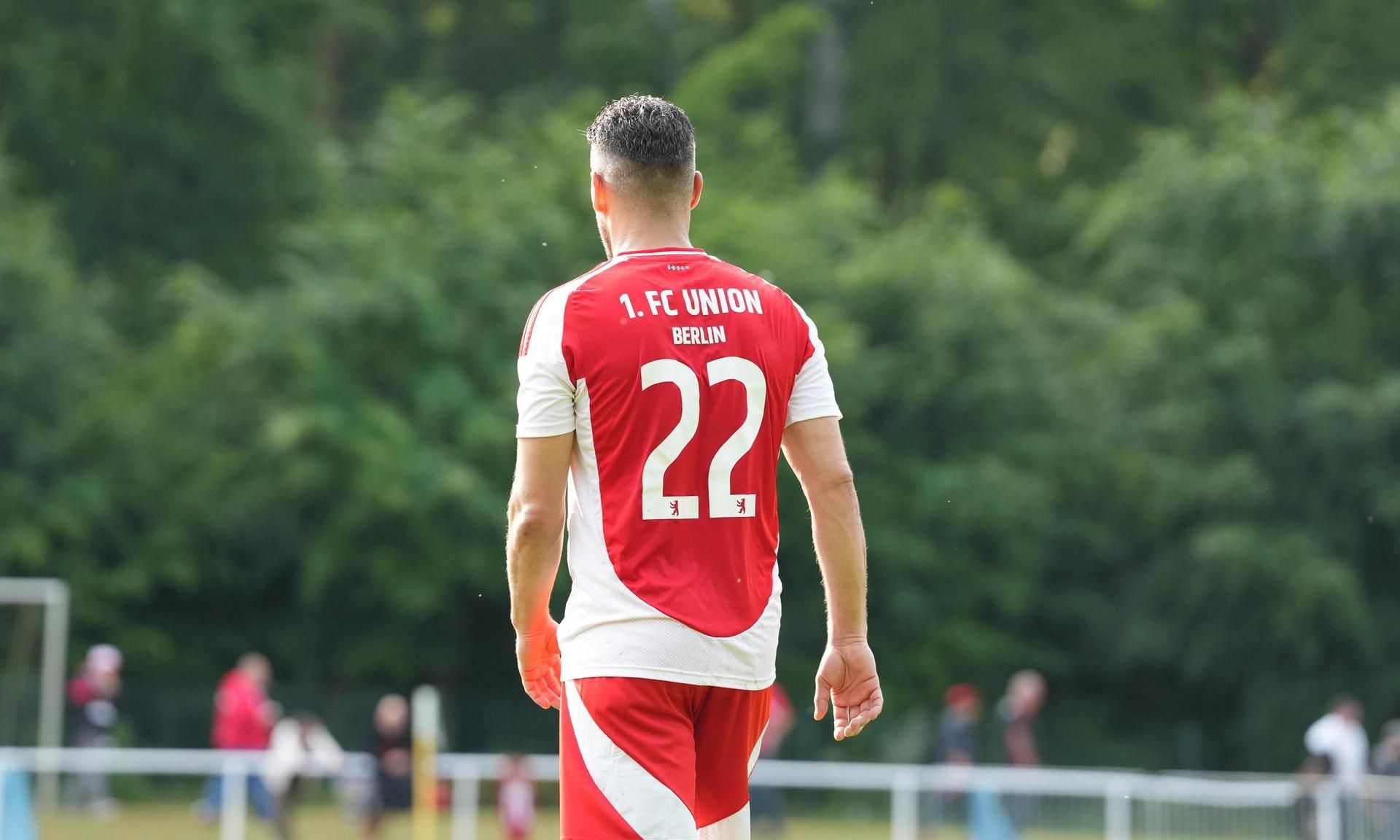 Spieler des 1. FC Union Berlin mit der Rückennummer 22, von hinten gesehen, auf einem Fußballplatz.