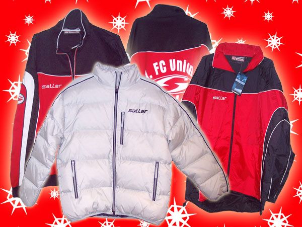 Drei Sportjacken in verschiedenen Designs und Farben auf rotem, schneebedecktem Hintergrund.