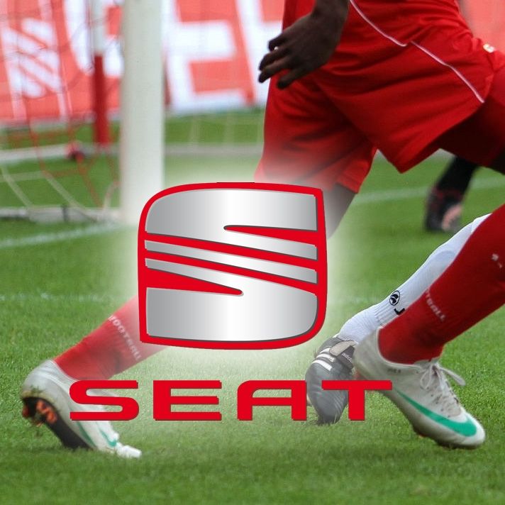 Zwei Fußballspieler in roten und weißen Trikots, die am Ball spielen, mit dem Logo von SEAT im Vordergrund.