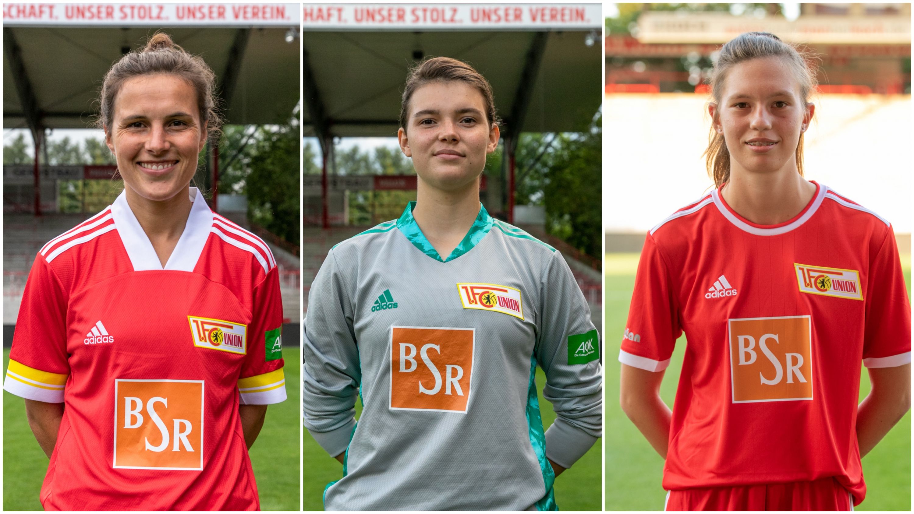 Drei Fußballspielerinnen in Uniformen des 1. FC Union Berlin, stehen lächelnd nebeneinander auf einem Sportgelände.