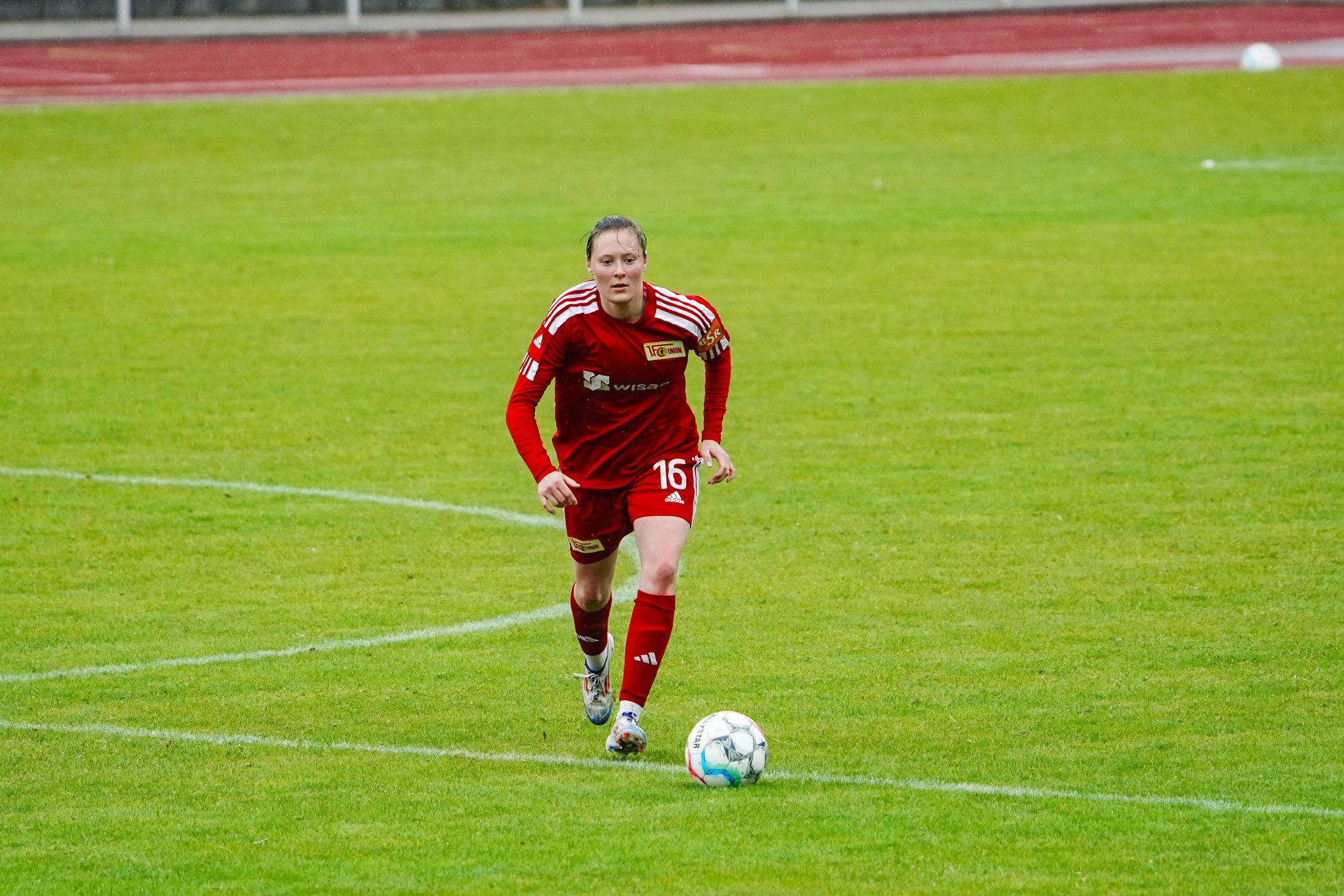 Eine Fußballspielerin in rotem Trikot mit der Nummer 16 läuft über das Spielfeld.