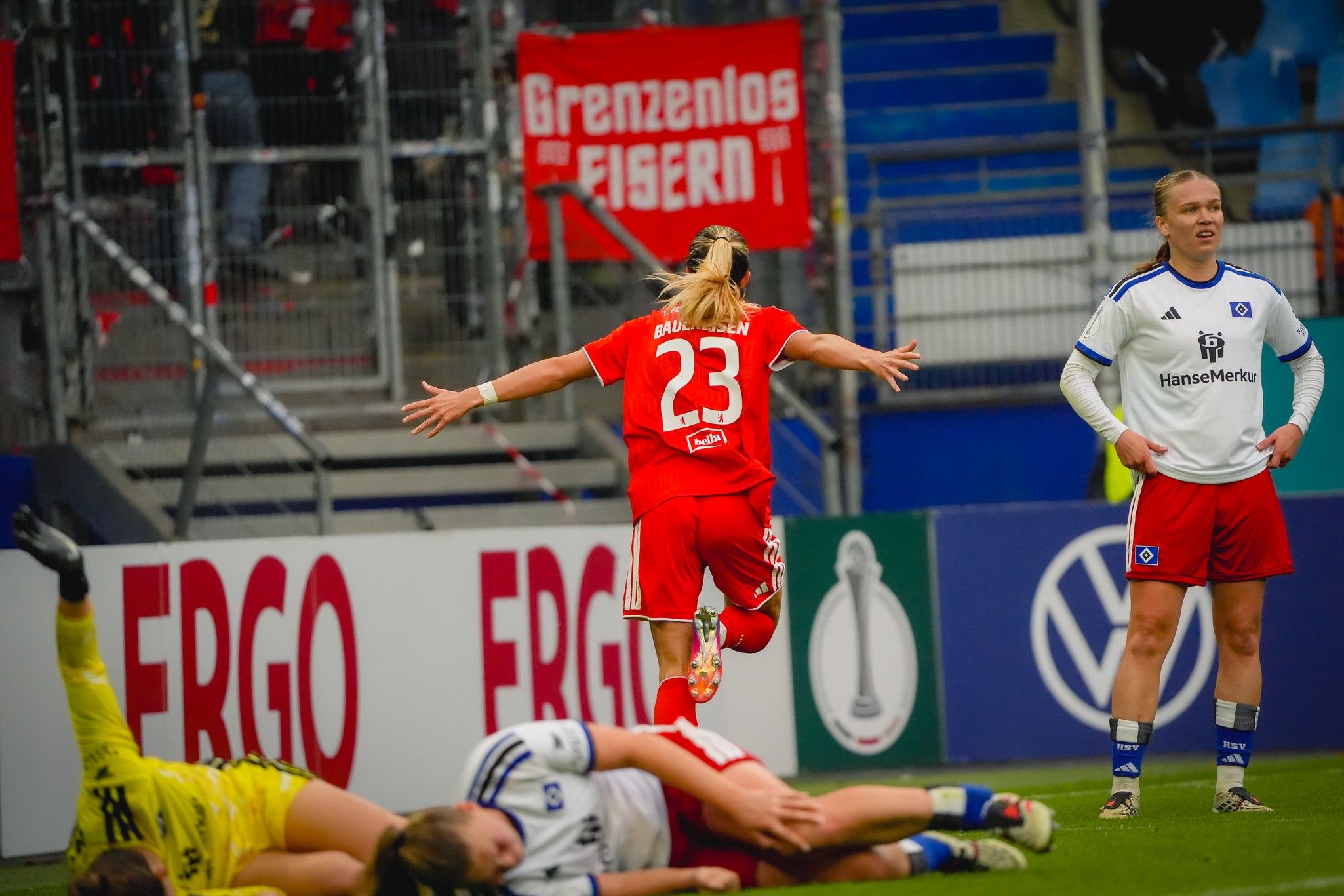Eine Spielerin mit der Nummer 23 springt jubelnd auf dem Spielfeld, während eine gegnerische Spielerin zuschaut.
